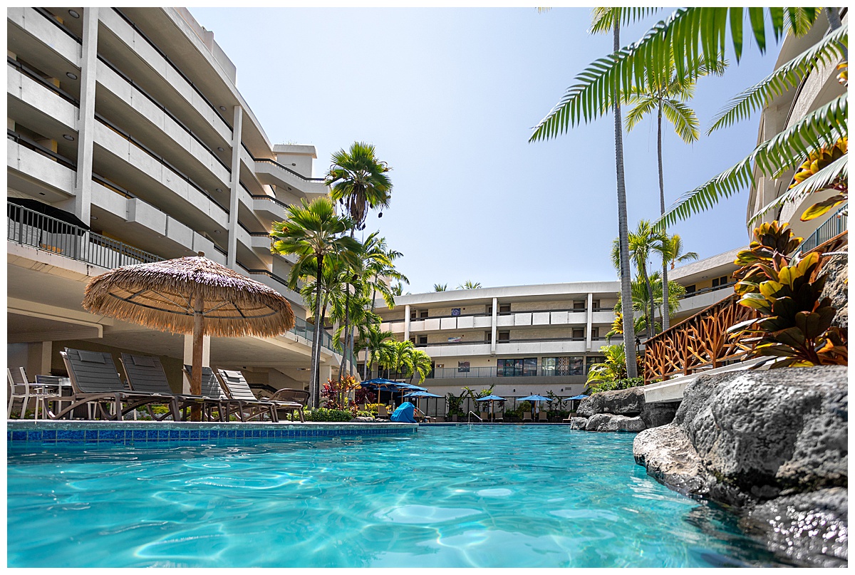 View of the Outrigger Kona Resort & Spa from inside the adults only pool. You can see rooms through the open air hallways.